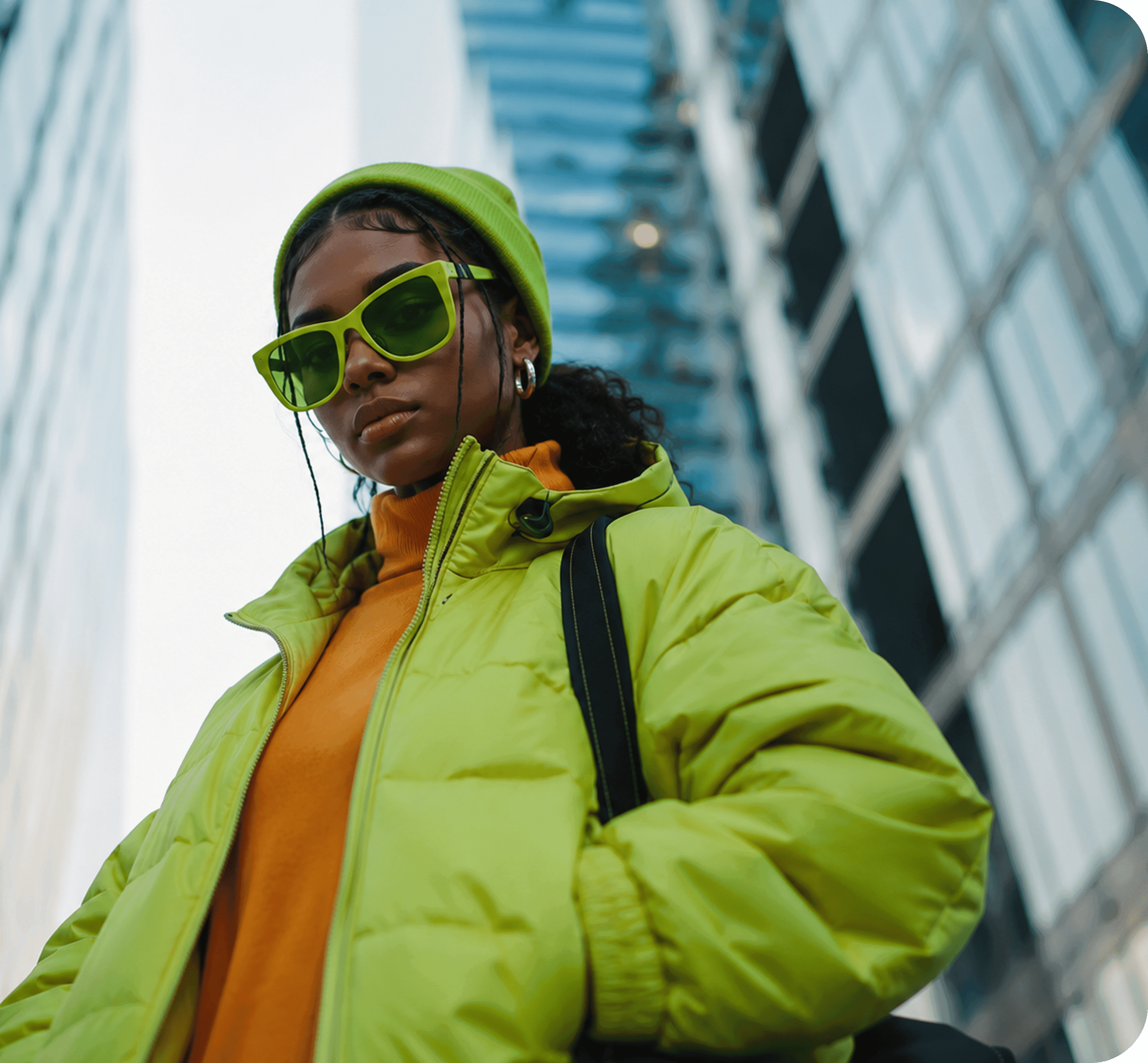 Person in a green jacket standing in front of a modern building
